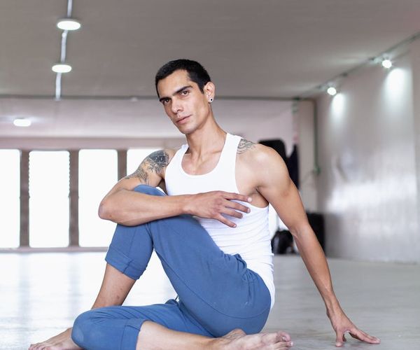 Focused male athlete in a warrior yoga pose in a modern studio.